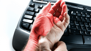 síndrome del túnel carpiano , mano en el teclado con el dedo rojo afectado por la enfermedad